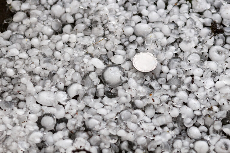 hail sized with a larger coin, hailstones on the ground after hailstorm, hail of great size